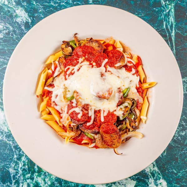 Penne pasta with tomato sauce, melted cheese, pepperoni, sausage, and sautéed vegetables.